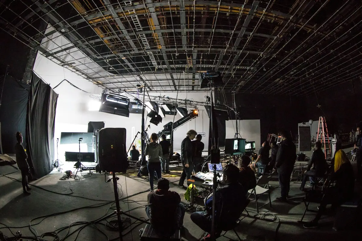 A film crew working on a large studio set with lights