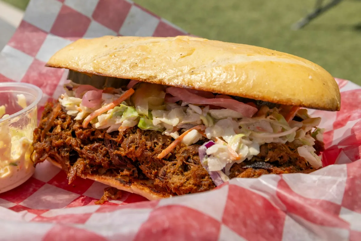 A soft roll filled with pulled pork and coleslaw